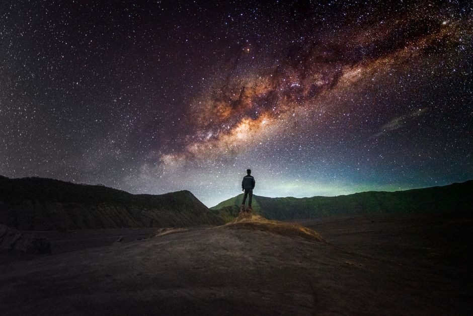 Person silhouetted against stunning Milky Way galaxy in East Java, Indonesia, inspiring exploration.